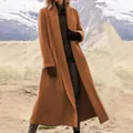 Detalle de un abrigo largo de lana color óxido para mujer en un paisaje de montaña - S / Tops / Marrón