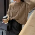 Detailed lifestyle shot of a woman wearing a chunky cable knit sweater and leather skirt - One Size / Tops / Milk Coffee