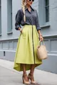 Fashionable high-low chartreuse skirt with front zipper and side pockets on street - Yellow