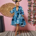 Detail view of denim patchwork print dress with deep V-neck and high-low hem design - Denim Blue