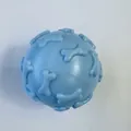 Close-up view of a light blue TPR rubber squeaky dog toy ball with raised bone patterns - Macaron Blue Bone Ball