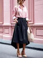 Full-length detail of a dark asymmetrical midi skirt with front zipper and side pockets - S / Bottoms / Black