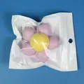 Flower shaped spinning catnip ball toy for cats in individual zip-lock packaging bag - Purple & Yellow