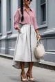 Detailed view of the front zipper and high-low hem on the chic irregular midi skirt. - S / Bottoms / Apricot