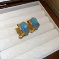 Primo piano di orecchini vintage a cerchio C in oro 18k con zirconi blu micro-pave - Stile Oro Blu (HE35862)