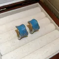 Primo piano di orecchini vintage a forma di C con vivaci pietre di zircone blu pavé - Stile Argento Blu (HE35862)