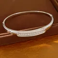 Detailed view of a silver oval bangle bracelet with shimmering zircon stone inlay. - Silver