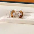 Detailansicht von Vintage Tigerauge-Ohrringen mit Zirkonia-Sternenmotiv in ovaler Form - Ohrstecker / Silbernadel / Hellkaffeegold
