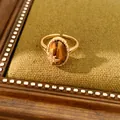 Retro verstellbarer goldener Ring mit ovalem Tigerauge und funkelndem Zirkonstern - offener Ring / Gold