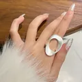 Detail van een matzilveren ovale holle ring gedragen aan de wijsvinger met bont. - Mat Zilver