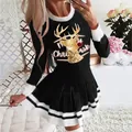 Close-up detail of women's black long sleeve pleated party dress with golden reindeer print - S / Dresses / Black