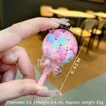 Detailopname van roze lolly vloeibare zandbedel met gekleurde bonen en vlokken. - Zonder Sleutelhanger (1 Stuk) / Roze Lichtgevende Lolly