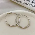 Close-up of elegant copper gold plated twisted hoop earrings with a shiny finish - Twisted Texture Earring (YG4810) / 4cm Size / Gold