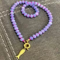 Close-up of purple abacus bead necklace with gold fish charm and pink knotted cord - Purple Stone Necklace with Metal Fish Pendant / 43cm / Purple
