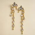 Primer plano de elegantes pendientes de borla dorados con brillantes strass. - Dorado
