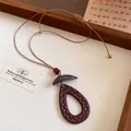 Vue détaillée d'un collier avec pendentif en goutte tressé de style chinois, cordon marron. - Brun - Goutte d'eau