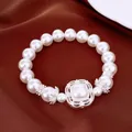 Primer plano de una lujosa pulsera elástica de perlas y circón sobre seda marrón - Estilo de Acento Cuadrado