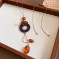 Détail d'un collier en cuir de style chinois avec des perles de bois ambrées élégantes - Marron