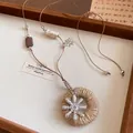 Détail du pendentif en jute avec fleur argentée sur un cordon perlé de style chinois - Argent-Café