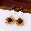 Dettaglio degli orecchini etnici retrò con fiori intrecciati e perle di legno - Stile Fiore in Rafia (HE35827) / Caffè