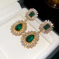 Detailed macro view of vintage emerald green teardrop earrings with shimmering diamond halo. - Silver Earring Post - Gold - Green