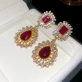 Detailed macro view of vintage palace style red stone drop earrings with crystals - Silver Earring Post-Gold-Red