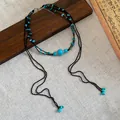 Detailed view of bohemian multi-layer necklace with turquoise beads and long tassels - Black and Blue Style