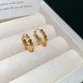 Close-up macro shot of 18k gold plated zircon hoop earrings with wavy design details - Clasp Back / Gold
