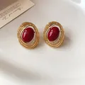 Detailansicht der ovalen Vintage-Ohrstecker in Goldoptik mit einem roten Harz-Cabochon - Rot