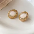 Detailaufnahme der Vintage-Ohrstecker in Gold-Ovalform mit weißem Harz-Mittelpunkt - Weiß