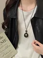 Macro detail view of a vintage black acrylic round pendant necklace on a model - Necklace-Black