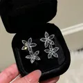 Detailansicht von funkelnden Zirkonia-Blumenohrsteckern in einer schwarzen Samtschachtel - Silber