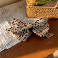 Primer plano detallado de pasador de pelo vintage con lazo de tela y estampado de leopardo - Clip Giratorio / Café Claro