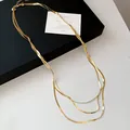 Detailaufnahme der Textur einer dreilagigen goldenen Schlangenkette für Damen - Gold