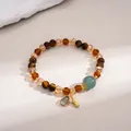 Detailed view of vintage tiger eye and glass beaded bracelet with gold charm - Gold-Coffee-Blue