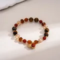 Vintage tiger eye stone beaded bracelet with a gold acorn charm on textured background - Gold-Coffee-Red