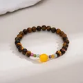 Close-up of tiger eye beaded bracelet with a central yellow bead in retro style - Coffee-Yellow