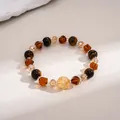 Close-up detail of tiger eye stone and amber glass beads on a vintage beaded bracelet. - Brown, Yellow, Irregular