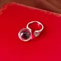 Nahaufnahme eines silbernen Rings mit einer klaren Harzkugel und einem funkelnden Zirkon - Offener Verstellbarer Ring (Silber/Lila) / Silber