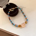 Detailweergave van handgemaakte kralenarmband met doorschijnende bloemgesneden kraal - Blauw-Bruin