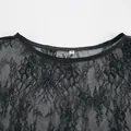 Gros plan du col d'une robe en dentelle noire avec étiquette de taille M sur fond blanc. - S / Robes / Noir