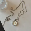 Luxe zilverkleurige trui ketting met een unieke geometrische kwartshorloge hanger - Rond / Zilver