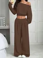 Femme portant un ensemble marron deux pièces avec crop top et un pantalon large chic - Brun Foncé