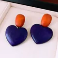 Close-up of vintage wooden heart pendant earrings with orange and purple color blocking. - Heart Pendant Style (HE35856) / Purple and Orange
