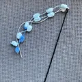 Cat teaser wand featuring blue and white pom-poms with a small bell on a long black pole - Pole Length Approx 52cm / Blue & White