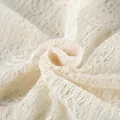 Vista ravvicinata del delicato pizzo jacquard color crema per il completo estivo da vacanza - Taglia S / Top E Pantaloni / Albicocca