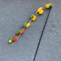 Interactive colorful pom-pom cat teaser wand with bell on grey textured background. - Pole Length Approx 52cm / Green Yellow Orange