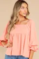 Detailed view of women's elegant coral peach square neck blouse featuring puff sleeves. - S / Tops / Pink