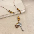 Detailansicht der Ethno-Halskette mit Herz- und Schlüsselanhänger aus Holz und Leder - Holz Kokosnussschale Stil / Silber Braun