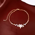 Detailopname van een 18K vergulde verstelbare armband met een fonkelende zirconia bloem - Goud
